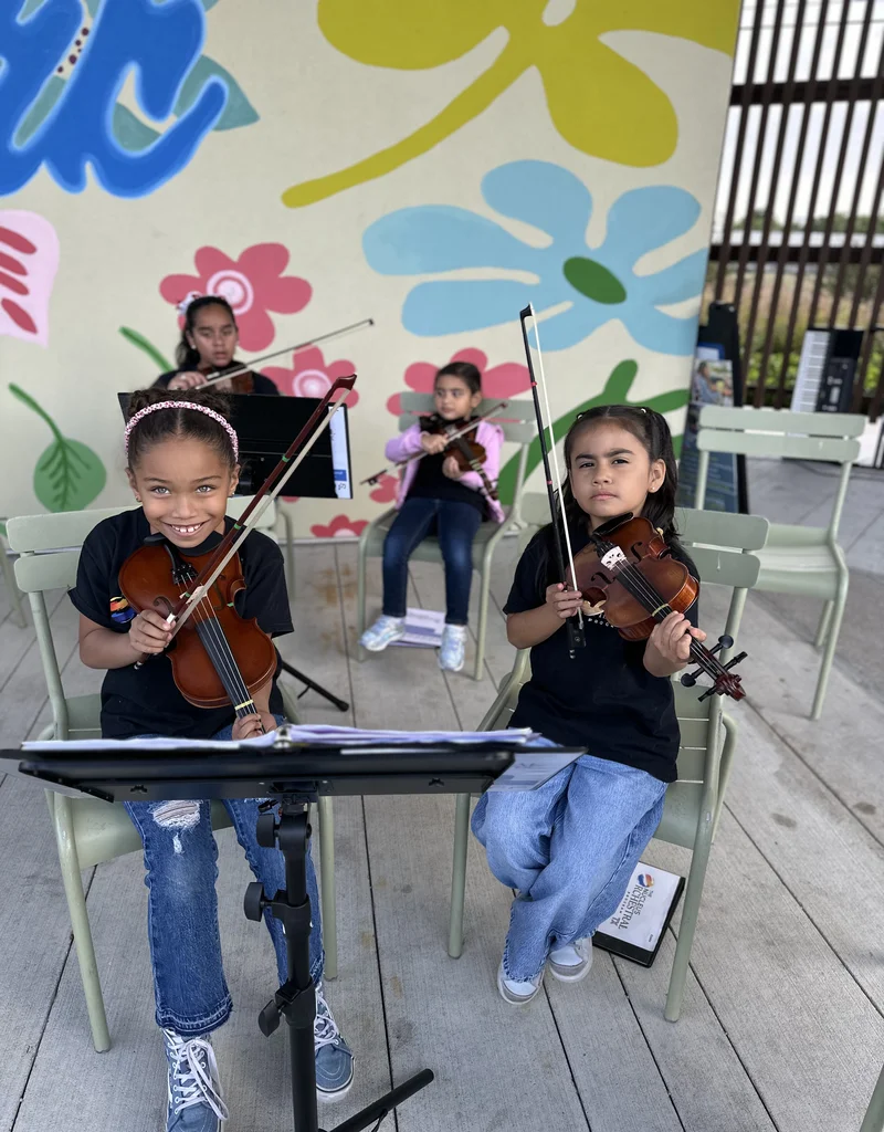 Alumnas del programa infantil The Nucleus Orchestra Texas en el Ciclo de Conciertos en el Distrito de Woodchase tocando violin