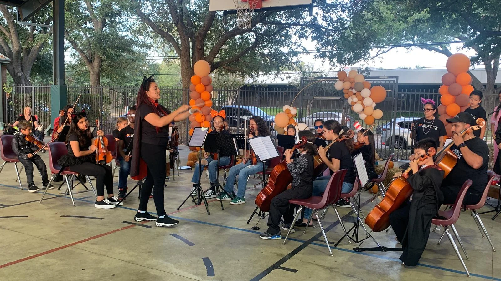 Profesora Katerine Rivas junto a sus alumnos del programa de orquesta infalntil y juvenil the nucleus orchestral program en evento de texas